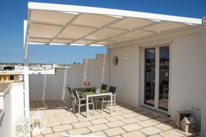 eine Terrasse mit einem Tisch und Stühlen auf dem Dach in der Unterkunft Stupenda Mansarda vista Mare in Torre Pali 