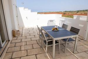 einen blauen Tisch und Stühle auf einer Terrasse in der Unterkunft Stupenda Mansarda vista Mare in Torre Pali 