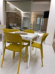カステッランマーレ・デル・ゴルフォにあるLoft Incantevole Castellammare del Golfoのダイニングルーム(白いテーブル、黄色の椅子付)