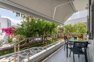balkon ze stołem, krzesłami i drzewami w obiekcie Lemonokipos, holiday house with private pool w mieście Sisi