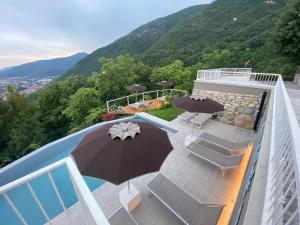 d'un balcon avec une piscine entourée de parasols et de chaises. dans l'établissement La cornice sul Garda - Your Home, à Villanuova sul clisi
