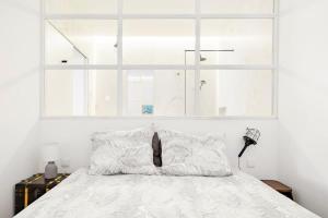 リスボンにあるCharming & Modern Flat close to Time Out Marketの白いベッド(枕2つ付)、窓が備わります。