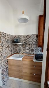 cocina con fregadero y azulejos en la pared en Casa di Zio, en Alghero