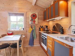 Føllenslevにある5 person holiday home in F llenslevの木製の壁のキッチン(テーブル、シンク付)