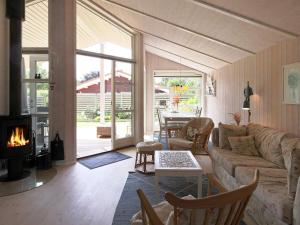 sala de estar con sofá y chimenea en 4 person holiday home in F llenslev, en Føllenslev