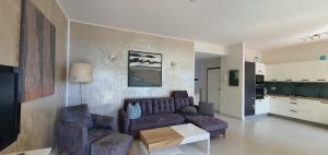a living room with a purple couch and two chairs at Beautiful Place a Lago d'Orta mit direktem Seezugang in Omegna