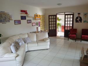 sala de estar con sofá blanco y silla roja en Casa do Fábio en João Pessoa