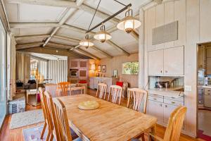 cocina y comedor con mesa de madera y sillas en When the Blue of the Night Meets the Gold of the Day, en Hayden