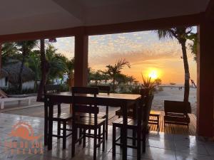 a dining room with a table and chairs and the sunset at Pousada Por do Sol in Jericoacoara
