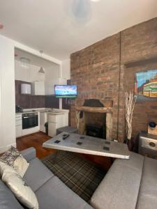 a living room with a couch and a stone fireplace at Glasgow City Centre Apartment in Glasgow