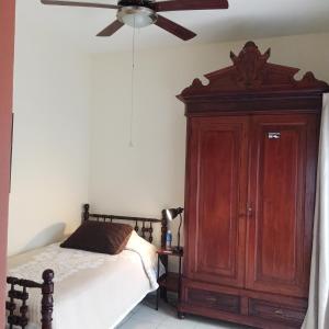 1 dormitorio con 1 cama y ventilador de techo en Posada Galeria Alberto Sedas en Huatusco de Chicuellar