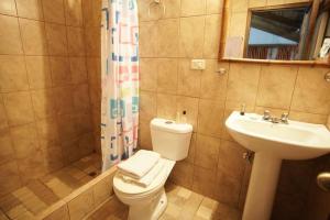 een badkamer met een toilet, een wastafel en een douche bij Mindo cozy house in Mindo