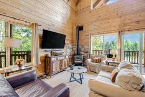 a living room with a flat screen tv and a fireplace at Log Cabin Luxury in Snoqualmie Pass