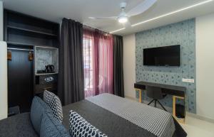 um quarto com uma cama e uma televisão na parede em Hotel Perla del Sur em Torremolinos