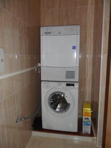 uma máquina de lavar e secar roupa numa pequena casa de banho em Pensión la Posada em Tineo