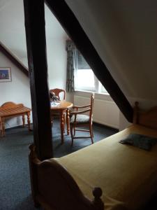 Schlafzimmer mit einem Bett, einem Tisch und Stühlen in der Unterkunft Landgasthaus Hesse in Hameln