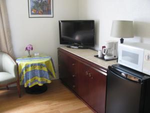 um quarto de hotel com uma televisão e um micro-ondas em Motel de l'Outlet em Magog-Orford