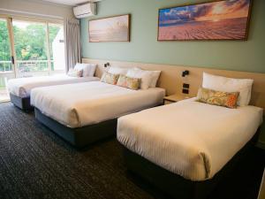 Habitación de hotel con 2 camas y ventana en Nightcap at Hinterland Hotel Nerang, en Gold Coast