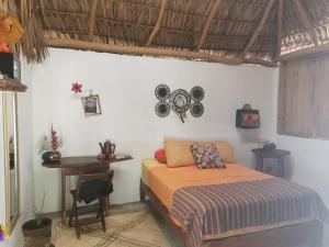 a bedroom with a bed and a desk and a table at La Máxima Drag Show & Bar LGBT in Zipolite