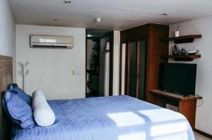 una camera con letto blu e televisore di Flat 308 Vista Mar a Salvador