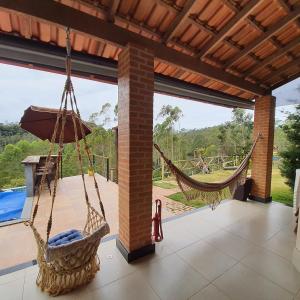 a patio with two hammocks and a pool at Recanto do Vale in Santa Teresa