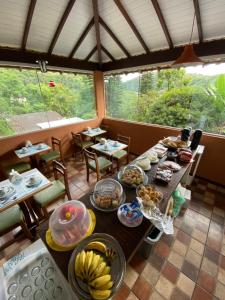a dining room with a table with food on it at Itaipava Cama e Café in Itaipava