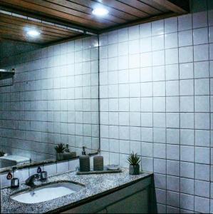 a bathroom with a sink and a tiled wall at Flat 308 Vista Mar in Salvador