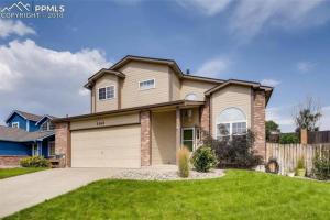 a house with a garage in a yard at 2 Master Suites/3 King Beds/4 Bath/Mins to Airport in Colorado Springs