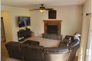 a living room with a leather couch and a fireplace at 2 Master Suites/3 King Beds/4 Bath/Mins to Airport in Colorado Springs