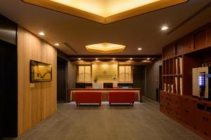 - un hall de bureau avec des chaises rouges et un bureau dans l'établissement Tosei Hotel Cocone Asakusa, à Tokyo