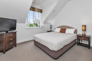 une chambre avec un lit et une télévision à écran plat dans l'établissement Russell Cottages - Russell Holiday Home, à Russell 23 autres photos