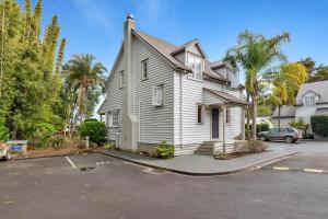 une maison blanche avec une voiture garée sur un parking dans l'établissement Russell Cottages - Russell Holiday Home, à Russell