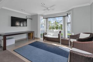 un salon avec une télévision, un bureau et des chaises dans l'établissement Russell Cottages - Russell Holiday Home, à Russell