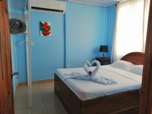 1 dormitorio con 1 cama con 2 cisnes hechos de toallas en Casa de Campo Heliconia en Fortuna