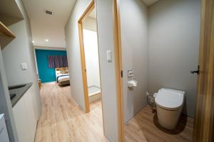 La petite salle de bains est pourvue de toilettes et d'un miroir. dans l'établissement Hotel S-Presso East, à Osaka