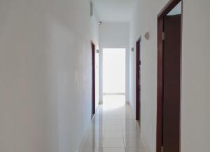 a hallway with white walls and black doors at RedDoorz near Istana Plaza 3 in Bandung +3 photos