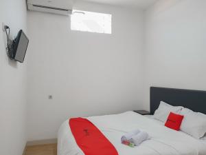 Schlafzimmer mit einem Bett mit roter Krawatte in der Unterkunft RedDoorz near Istana Plaza 3 in Bandung