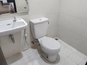 a white bathroom with a toilet and a sink at RedDoorz near Istana Plaza 3 in Bandung