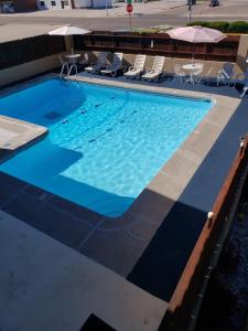 a large swimming pool with chairs and umbrellas at Americas Best Value Inn North Platte in North Platte