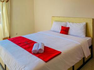 a white bed with red and white towels on it at RedDoorz near Lippo Mall Yogyakarta in Demangan