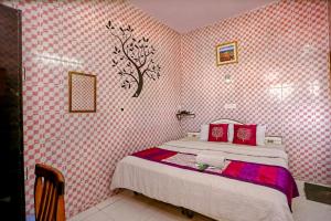 The Trekkers Hostel - Dehradun في دهرادون: غرفة نوم بسرير وورق جدران وردي وبيض