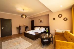 a bedroom with a bed and a couch and a table at Clabucet Studio in Predeal