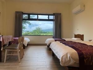 1 Schlafzimmer mit 2 Betten und einem großen Fenster in der Unterkunft Longtian Prosperity BnB in Luye
