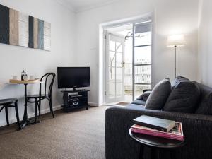 a living room with a couch and a table with a television at Lake Daylesford Apartments 2A in Daylesford