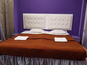 a bedroom with a large bed with two towels on it at NIASHA in Mangalore