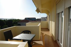 einen kleinen Balkon mit einem Tisch und Stühlen auf einem Gebäude in der Unterkunft Apartments Adria in Turanj