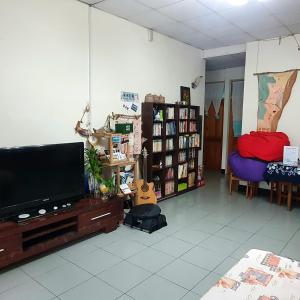 a living room with a flat screen tv and a guitar at 春季優惠 續住半價 太麻里 左奶奶的家 in Taimali