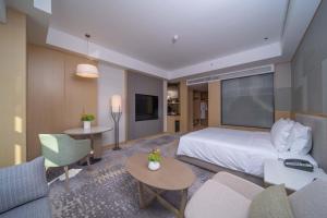 a hotel room with a bed and a living room at Holiday Inn Qinhuangdao Haigang in Qinhuangdao +21 photos