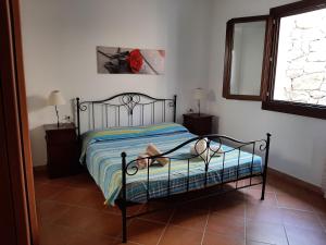 una camera da letto con un letto e una finestra di Appartamenti I Mandorli a Budoni