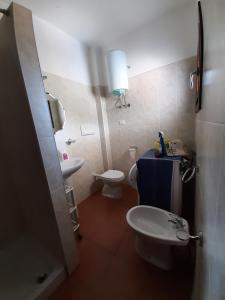 un piccolo bagno con un water e un lavandino di Appartamenti I Mandorli a Budoni Altre 37 foto